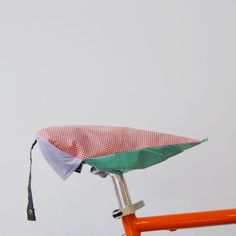 an orange bicycle with a green and white seat cover