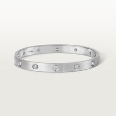 Cartier - LOVE bracelet, 10 diamonds - Bracelet White gold/Gold - LOVE bracelet, white gold 750/1000, set with 10 brilliant-cut diamonds totaling 0.96 carats. Comes with a screwdriver. Width: 6.1 mm. Created in New York in 1969, the LOVE bracelet is an icon of jewelry design: a close fitting, oval bracelet composed of two rigid arcs which is worn on the wrist and removed using a specific screwdriver. The closure is designed with two functional screws placed on either side of the bracelet: you wi Cartier Love Bracelet Diamond, Trinity Bracelet, Bracelet White Gold, Bracelet Love, Diamond Bangles Bracelet, Detailed Jewelry, Love Bracelet, Diamond Bangle, Bracelet Collection