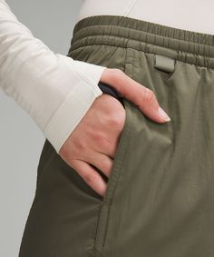 a woman's hand is on her waist as she holds the pocket of her pants