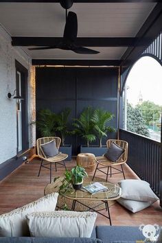 an outdoor living area with wicker furniture and potted plants