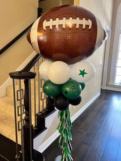 a football balloon bouquet on top of a stair case