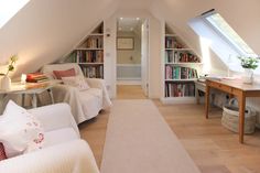 an attic bedroom with bookshelves and white furniture