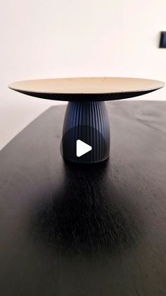 a black table with a wooden top and an arrow on it's center piece