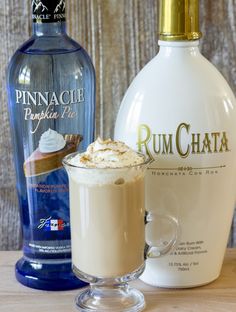 a bottle of rumchata next to a glass filled with ice cream and whipped cream