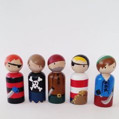 a group of wooden toy figurines sitting next to each other on a white surface