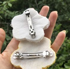 a person holding a piece of fabric with a metal clasp on it