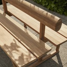 a wooden bench sitting on top of a sidewalk