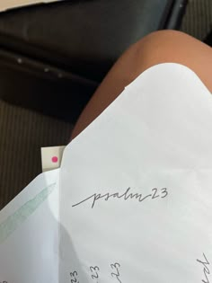 a woman's leg with writing on it sitting next to a piece of paper