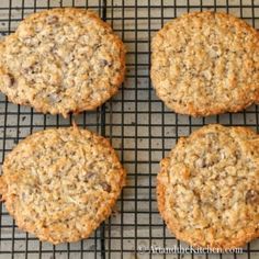 four oatmeal cookies sitting on top of a cooling rack next to each other