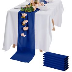 the table is set with blue place mats and white linens, along with flowers