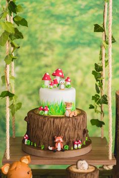 there is a cake with mushrooms on it and other decorations around the tree stumps