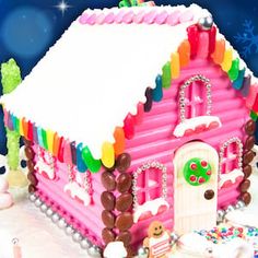 a pink house with decorations on the roof and windows, in front of snowflakes