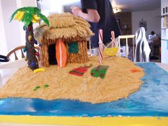 there is a cake made to look like a hut on the beach with palm trees