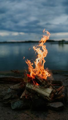 a fire burning on the ground next to water