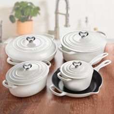 white cast iron cookware set on wooden table