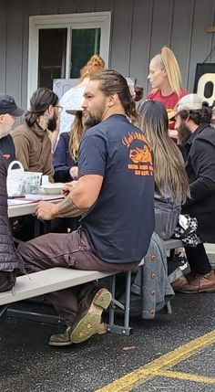 a group of people sitting at picnic tables