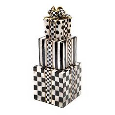 three black and white gift boxes stacked on top of each other with a gold bow