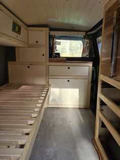 the inside of a camper with drawers and bed in it's center area