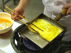 a person cooking food on top of a stove with chopsticks in their hand