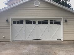 a white garage with three windows and two doors