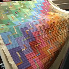 a colorful quilt is displayed on a table