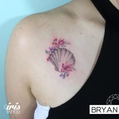 a woman with a tattoo on her shoulder has a fan in the shape of flowers