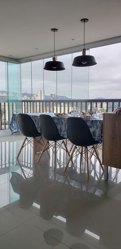 a table with four chairs in front of large windows