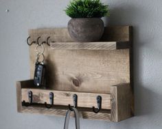 a potted plant on top of a wooden shelf next to two keys and a pair of scissors