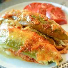 some food on a white plate with tomatoes