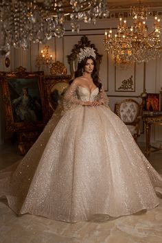 a woman in a ball gown standing next to a chandelier filled with lights