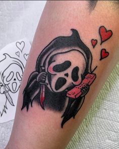 a girl with a skull and heart tattoo on her arm