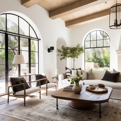 a living room filled with furniture and large windows