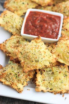 some fried food on a white plate with dipping sauce