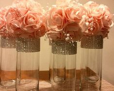 three vases with flowers in them sitting on a table