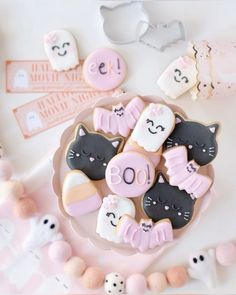 decorated cookies are on a plate next to other decorations and decorating items in pastel colors