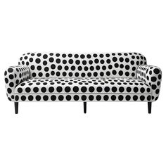 a black and white couch with polka dot print on it's back legs, sitting in front of a white background