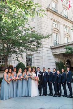 a group of people standing next to each other in front of a building