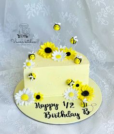 a birthday cake decorated with daisies and bees