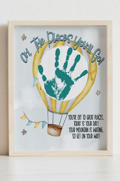 a hand print in a wooden frame that says, on the day you were born