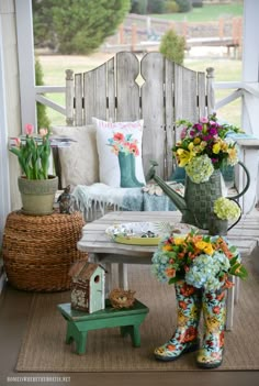 the porch is decorated with colorful flowers and gardening boots on it's side table