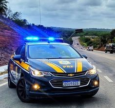 a police car with its lights on driving down the road