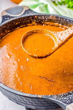 a ladle scooping some soup out of a pot