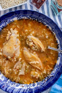 a blue and white bowl filled with chicken soup