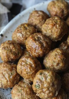 a white bowl filled with meatballs on top of a table