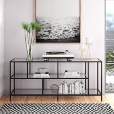 a record player sitting on top of a table next to a vase with plants in it