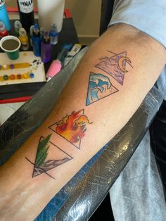 a man with a tattoo on his arm that has three triangles and an animal in it