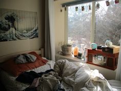 an unmade bed sitting in front of a window