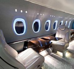 the interior of an airplane with white leather seats and blue accented walls is shown