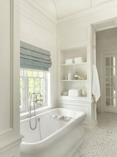 a white bathtub sitting next to a window in a bathroom