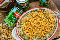 a bowl of green bean casserole next to cans of canned beans and seasonings